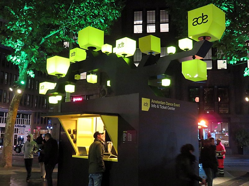 Amsterdam Dance Event 2016 Info & Ticket Center stand on Rembrandt Square in Amsterdam at night, lit by green cubes with the ADE logo.