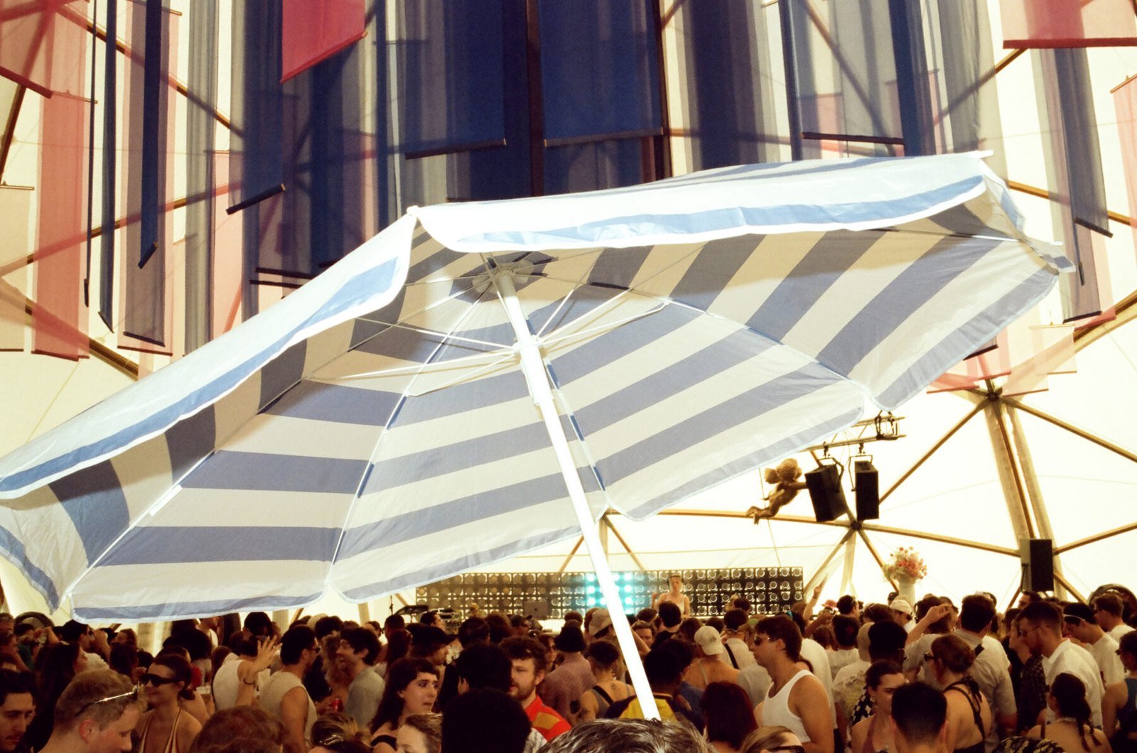 Crowd dancing under a striped parasol at GALA festival 2026.